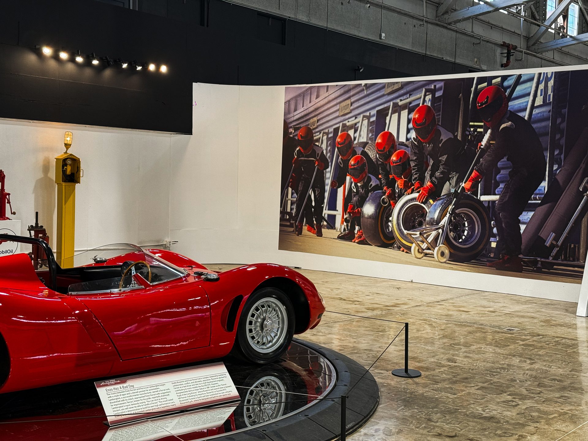 Enzo Has A Bad Day — Lamborghini exhibit with racing pit mural